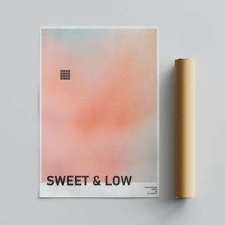 Urban typography poster with gradient peach design and text 'SWEET & LOW'. Placed next to a brown packaging tube.