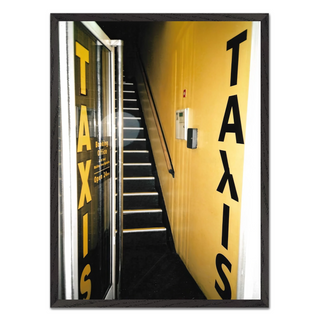 Urban 35mm film photograph of a taxi service front door with an edgy street art aesthetic, displayed in a premium black wooden frame.