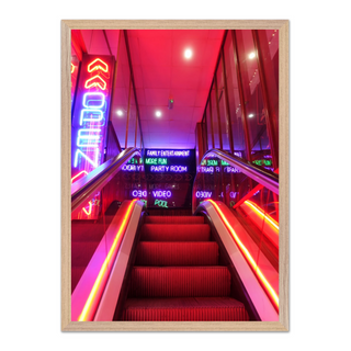 Vibrant urban wall art print of a neon-lit staircase with colorful lights and signage, designed for modern city interiors and displayed in a premium oak wooden frame.