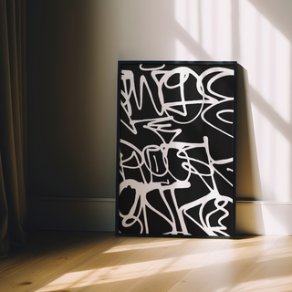 Graffiti Abstract black and white poster on a wooden floor with sunlight casting shadows.