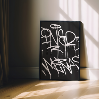 Black and white abstract art print featuring graffiti-style text on a black background, displayed in a premium black wooden frame.