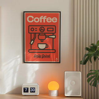 Red Poster with coffee machine illustration and 'Coffee Daily Grind' text on a red background displayed in black wooden frame. Placed in a minimal room next to plant and lamp.