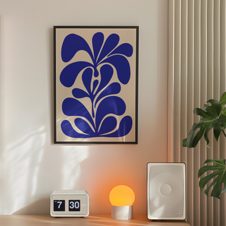 Hand drawn botanical floral abstract blue illustration on a beige background. Displayed in a black wooden frame. Placed in a minimalistic decor room next to lamp plant and speakers.