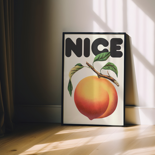 Framed artwork featuring a vintage-style peach and leaves with the word 'NICE' in bold text on a beige background, displayed in a premium black wooden frame.