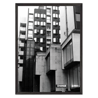 Black and white photographic art print featuring a Brutalist architecture cityscape with bold geometric shapes and industrial design elements. The photograph presents striking contrasts and shadows in an urban environment, offering a modern and contemporary visual style. Ideal for home decor, this print brings a sense of modernity and architectural elegance to living spaces. Perfect for those who appreciate unique urban photography and minimalist design aesthetics, reflecting the character of