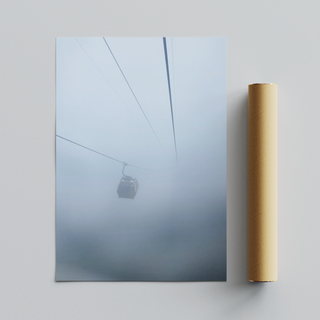 Framed photograph capturing a cable car in misty, foggy conditions, displayed next to cardboard tube packaging. 