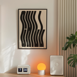 Framed typography art print saying "Chill' with black wavy lines on a beige background. Displayed in a black wooden frame. Placed in a minimal decor room next to plant and lamp. 