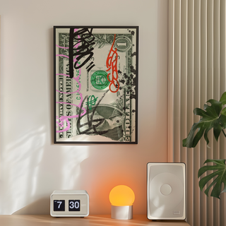 Framed dollar bill art on a wall with a clock, lamp, and plant below.
