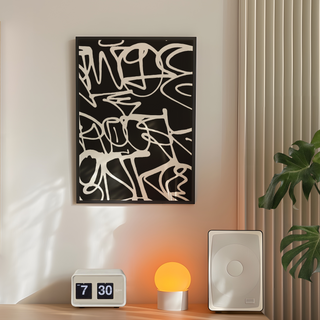 Graffiti black and white Abstract wall art with a digital clock, small lamp, and white box on a shelf.