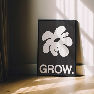 Framed artwork featuring a white abstract leaf design and the word 'GROW.' on a black background, displayed in a premium black wooden frame.