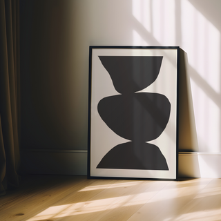 Minimalist black and white abstract poster with three bold black shapes stacked against a clean white background, showcased in a premium black wooden frame.