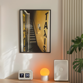 Urban 35mm film photograph of a taxi service front door with an edgy street art aesthetic, displayed in a premium black wooden frame. Placed on a bedroom wall next to speakers, plant and lamp.